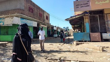 مدنيون سودانيون يمشون على طريق شبه مقفر مع إغلاق العديد من المتاجر لأسباب أمنية في مدينة القضارف شرق السودان (10 ك2 2024، أ ف ب).