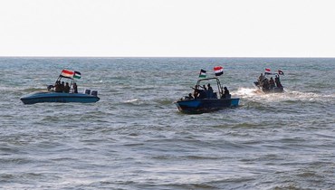 عناصر من خفر السواحل اليمنيين التابعين لجماعة الحوثي، يقومون بدوريات في البحر بينما يسير متظاهرون في مدينة الحديدة الساحلية على البحر الأحمر تضامنا مع فلسطينيي غزة (4 ك2 2024، أ ف ب).