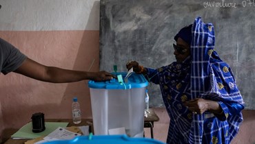 امرأة تدلي بصوتها في مركز اقتراع في موروني (14 ك2 2024ـ أ ف ب). 