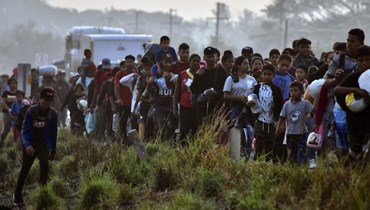 مهاجرون يسيرون ضمن قافلة تتجه نحو الحدود مع الولايات المتحدة، في أرياغا بولاية تشياباس بالمكسيك (8 ك2 2024، أ ف ب). 