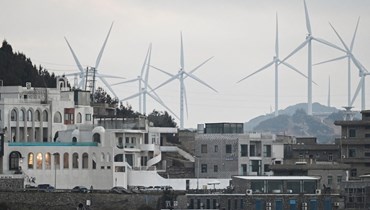 توربينات الرياح تظهر خلف منتجع في جزيرة بينجتان الصينيّة (أ ف ب). 