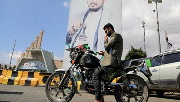 يمني بالقرب من صورة الزعيم الحوثي عبد الملك الحوثي في صنعاء (أ ف ب). 