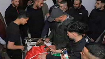 عائلة الشاب الفلسطيني توفيق عجاق الذي يحمل الجنسيّة الأميركيّة، والذي قُتل بنيران إسرائيليّة، تتجمّع حول جثّته  في مشرحة مستشفى في رام الله (أ ف ب). 