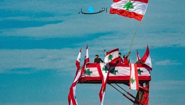 لبنانيون يرفعون العلم اللبناني.