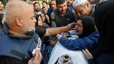 زوجة حمزة الدحدوح ووالده مدير مكتب "الجزيرة" في غزة وائل الدحدوح خلال تشييع حمزة الذي قضى بغارة جويّة (أ ف ب).
