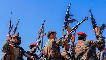 مقاتلون حوثيون يلوحون بأسلحتهم خلال مسيرة مناهضة لإسرائيل والولايات المتحدة في العاصمة اليمنية صنعاء (22 ك2 2024، أ ف ب).