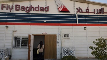 موظف يدخل مقرّ شركة الطيران العراقية "فلاي بغداد" في مطار بغداد الدولي (أ ف ب). 
