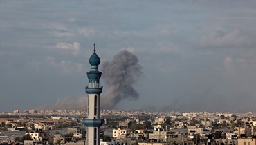صورة ملتطقة من رفح، تظهر الدخان يتصاعد فوق خان يونس في جنوب قطاع غزة خلال قصف إسرائيلي (24 ك2 2024، أ ف ب).