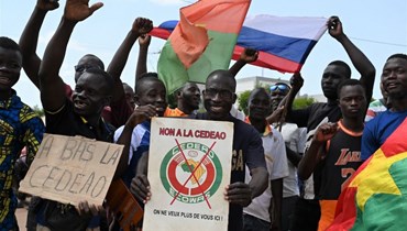 صورة ارشيفية- متظاهرون يحملون أعلام روسيا وبوركينا فاسو خلال احتجاجهم على "إكواس" في واغادوغو (4 ت1 2022، أ ف ب). 