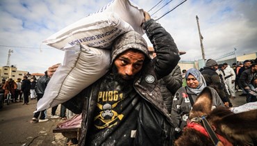يتلقى النازحون الفلسطينيّون مساعدات غذائية في مركز وكالة الأمم المتحدة لإغاثة وتشغيل اللاجئين الفلسطينيين (الأونروا) في رفح، جنوب قطاع غزة (أ ف ب). 