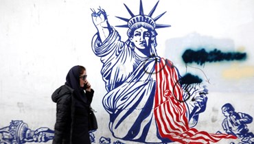  امرأة تمشي بجوار المبنى الذي كان يستضيف سابقاً سفارة الولايات المتحدة في طهران (أ ف ب). 