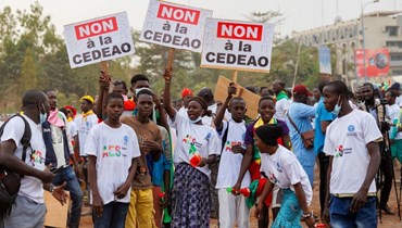 مؤيدون لتحالف دول الساحل  يحملون لافتات مناهضة لإكواس خلال مسيرة في باماكو للاحتفال بخروج مالي وبوركينا فاسو والنيجر من المجموعة الاقتصادية لدول غرب أفريقيا (1 شباط 2024، أ ف ب). 