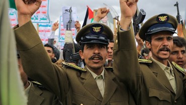 عناصر من قوات الأمن التابعة للحوثيين يرفعون بقبضاتهم خلال مسيرة في صنعاء دعما للفلسطينيين (9 شباط 2024، أ ف ب). 