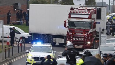 صورة ارشيفية- الشرطة ترافق شاحنة عثر فيها على عدد كبير من الجثث، خلال نقلها من منطقة صناعية في ثوروك بجنوب إنكلترا (23 ك1 2019، أ ب). 