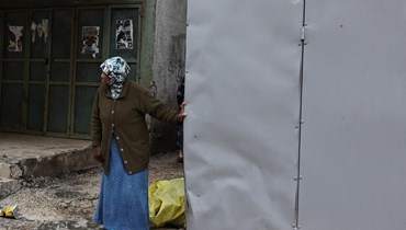 امرأة تتفقّد الأضرار بعد غارة إسرائيلية على مخيم طولكرم للاجئين الفلسطينيين في الضفة الغربية المحتلّة (أ ف ب). 