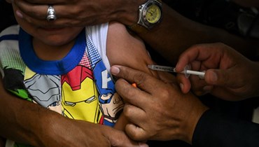 صبي يتلقى جرعة من لقاح ضد الحصبة والحصبة الألمانية في مركز صحي مجتمعي في حي ليديس في كراكاس (17 آب 2022ـ أ ف ب). 