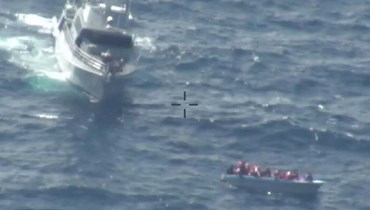 صورة نشرتها القوات المسلحة المالطية في 23 شباط 2024، وتظهر زورق دورية بالقرب من قارب المهاجرين قبالة مالطا خلال  عملية إنقاذ (أ ف ب).