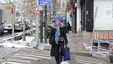 امرأة تسير في أحد شوارع طهران (أ ف ب). 