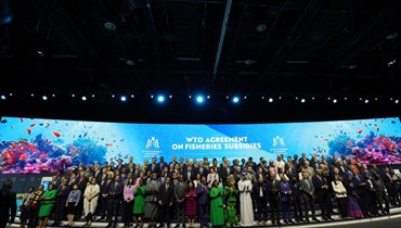 مندوبون يلتقطون صورة جماعية خلال جلسة حول دعم مصايد الأسماك خلال المؤتمر الوزاري الـ13 لمنظمة التجارة العالمية في أبوظبي (26 شباط 2024، أ ف ب).