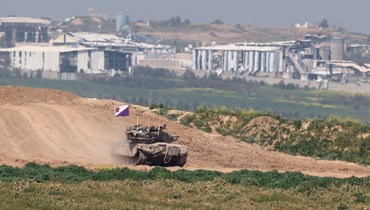 صورة ملتقطة من إسرائيل بالقرب من الحدود مع قطاع غزة، تظهر دبابة إسرائيلية خلال خروجها من غزة (28 شباط 2024، أ ف ب). 