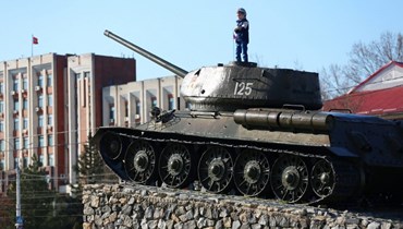 طفل وقف على دبابة سوفياتية وضعت كنصب تذكاري في وسط تيراسبول، عاصمة جمهورية ترانسدنيستريا(3 نيسان 2017، أ ف ب). 