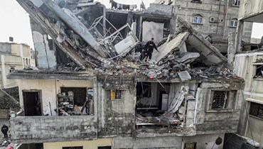 فلسطينيون يبحثون بين أنقاض منزلهم الذي دمرته غارة جوية إسرائيلية ليلية في مخيم رفح للاجئين في جنوب قطاع غزة (27 شباط 2024، أ ف ب).