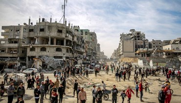 فلسطينيون تجمعوا في أحد الشوارع خلال إسقاط مساعدات إنسانية جوا في مدينة غزة (1 آذار 2024، أ ف ب). 