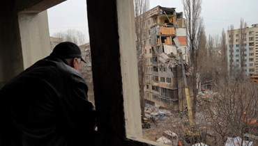 أحد السكان المحليين يشاهد أعمال الإنقاذ في موقع مبنى سكني متعدد الطوابق تعرض لأضرار بالغة، في أعقاب هجوم روسي بطائرة بدون طيار، في أوديسا، في (2 أذار 2024 - أ ف ب).