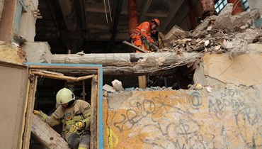 رجال إنقاذ يعملون في موقع مبنى سكني تضرر من جراء هجوم بطائرة روسية مسيرة في أوديسا (2 آذار 2024، أ ف ب).