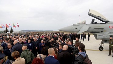 سياسيون وعسكريون يقفون قرب طائرات مقاتلة من طراز تايفون تابعة للقوات الجوية الإيطالية، خلال احتفال في القاعدة الجوية في مدينة كوكوفا جنوب العاصمة تيرانا (4 آذار 2024، أ ف ب). 