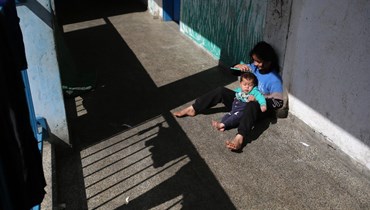 فتاة نازحة وشقيقها في مدرسة تابعة للأونروا تؤوي الفلسطينيين النازحين، في رفح  (أ ف ب). 