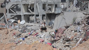فلسطيني جلس وسط منازل دمرها قصف إسرائيلي في خان يونس بجنوب قطاع غزة (6 آذار 2024ـ أ ف ب). 