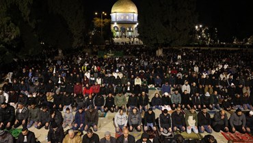  مصلون مسلمون فلسطينيون يؤدون صلاة العشاء المعروفة باسم "التراويح" خارج قبة الصخرة في مجمع المسجد الأقصى بالقدس خلال شهر رمضان المبارك (11 آذار، 2024 - أ ف ب).