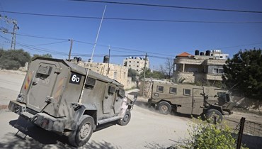 مركبات عسكرية إسرائيلية تقوم بدورية في أحد الشوارع خلال مداهمة لمنطقة مخيم جنين للاجئين في الضفة الغربية المحتلة (12 آذار 2024، أ ف ب).