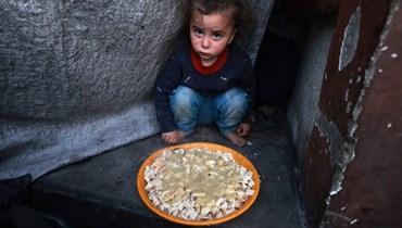طفل ينتظر طعاماً في غزّة (أ ف ب).