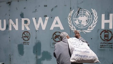 لاجئ فلسطيني أمام أحد مستودعات الأوتروا (أ ف ب) 