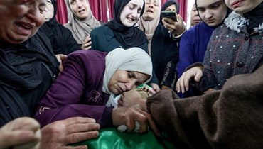 أقرباء يحيطون بجثة محمود أبو الهيجا، أحد الشابين الفلسطينيين اللذين قُتلا خلال مداهمة للجيش الإسرائيلي قبل يوم في جنين بالضفة الغربية المحتلة، قبل تشييعه (13 آذار 2024، أ ف ب). 