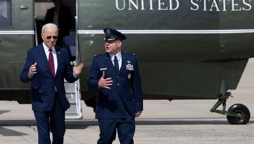 العقيد في القوات الجوية الأميركية بول باولوك الرئيس الأميركي جو بايدن عند وصوله على متن طائرة الرئاسة قبل مغادرته قاعدة أندروز المشتركة في ماريلاند، (في 13 آذار 2024 - أ ف ب).