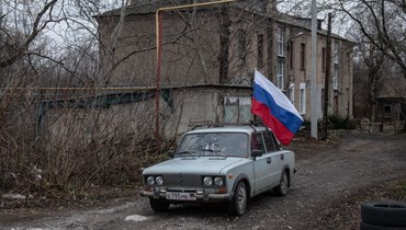 ​ أعضاء لجنة الانتخابات الروسية يتنقلون بالسيّارة عبر المناطق السكنية (أ ف ب). 