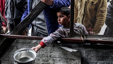 طفل فلسطيني ينتظر للحصول على طعام في مدينة رفح بظلّ تحذير من مجاعة في غزّة (أ ف ب).