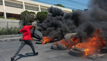 متظاهر يحرق الإطارات في بور أو برنس خلال احتجاج عقب استقالة رئيس وزراء هايتي أرييل هنري (12 آذار 2024، أ ف ب). 