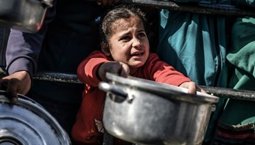 طفلة تنتظر حصّة من الطعام في غزّة في ظل الحرب.