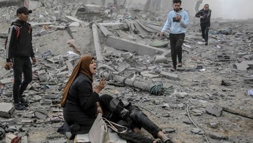  امرأة فلسطينية تحتضن طفلاً جريحاً بعد القصف الإسرائيلي على وسط مدينة غزة (18 آذار 2024 - أ ف ب).
