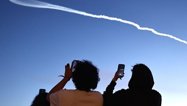 أشخاص يلتقطون صوراً لصاروخ  Falcon 9 في لوس أنجلوس (أ ف ب). 