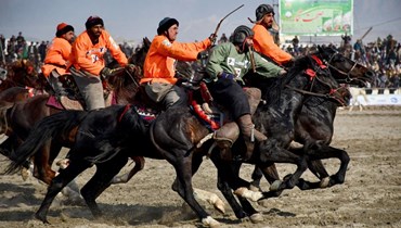 فرسان أفغان من فريقي ياما بتروليوم (البرتقالي) وبغلان يتنافسون في نهائي بطولة دوري البوزكاشي في مزار شريف (8 آذار 2024، أ ف ب). 