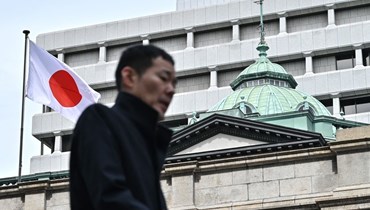 رجل يسير بجوار المقر الرئيسي لبنك اليابان في وسط طوكيو (أ ف ب). 