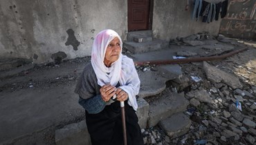 امرأة فلسطينية مسنّة تقف عند الأنقاض في مخيم رفح للاجئين في جنوب قطاع غزة (21 آذار 2024 - أ ف ب).