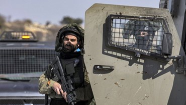 جندي إسرائيل يترجّل من آلية ويحمل سلاحاً.