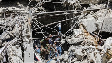 رجال إنقاذ يبحثون بين أنقاض مبنى ملحق بالسفارة الإيرانية بعد يوم من غارة جوية في دمشق (2 نيسان 2024، أ ف ب). 
