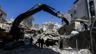 رجال إنقاذ يبحثون بين أنقاض مبنى ملحق بالسفارة الإيرانية بعد يوم على غارة جوية في دمشق (2 نيسان 2024، أ ف ب). 